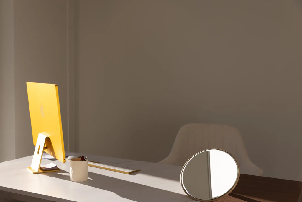 Bureau de consultation design et lumineux chez Gemelia, avec un ordinateur et un miroir pour l'analyse du visage.