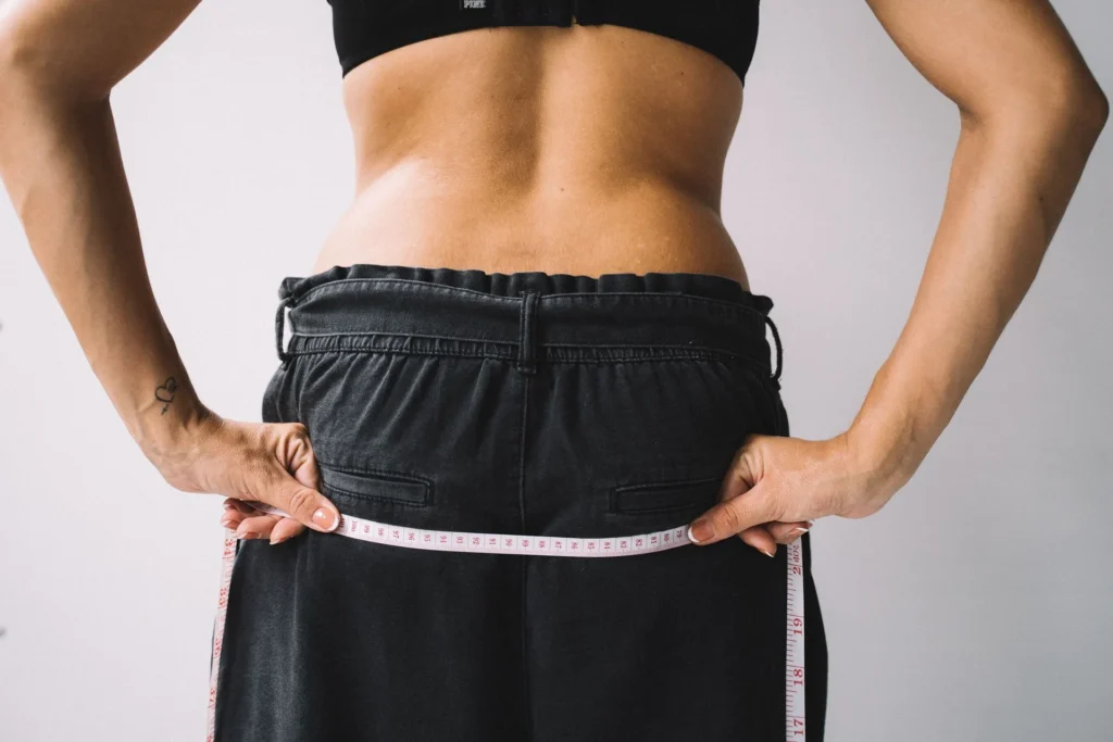 Femme mesurant son tour de taille avec un mètre ruban