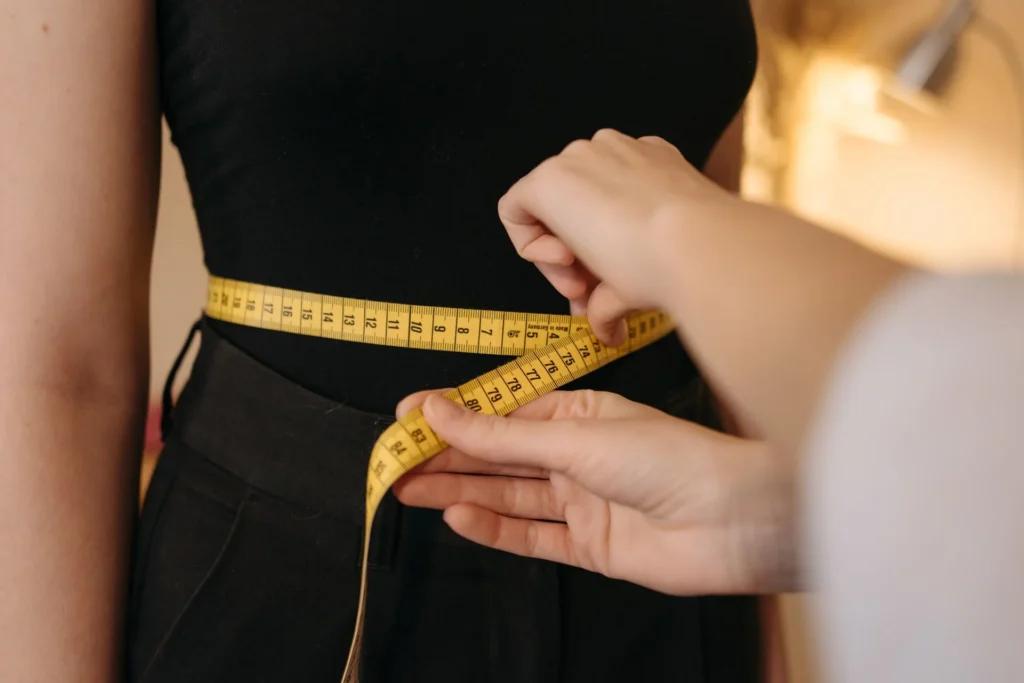 Mesure du tour de taille avec un mètre ruban jaune