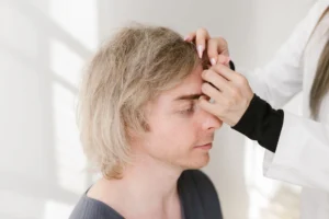 Médecin examinant la ligne frontale d'un patient en consultation