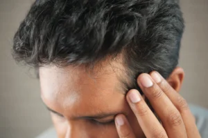 Homme passant la main dans ses cheveux, gros plan sur la ligne frontale