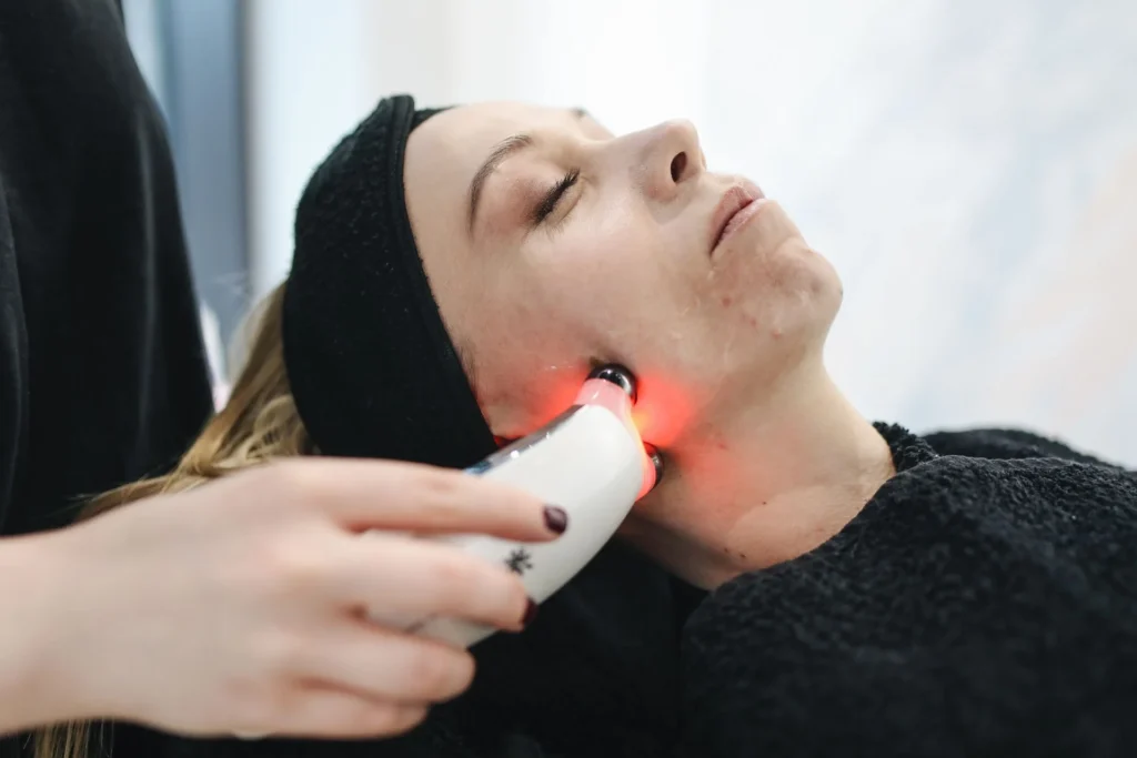 Patiente détendue, les yeux fermés, pendant un soin du visage par appareil