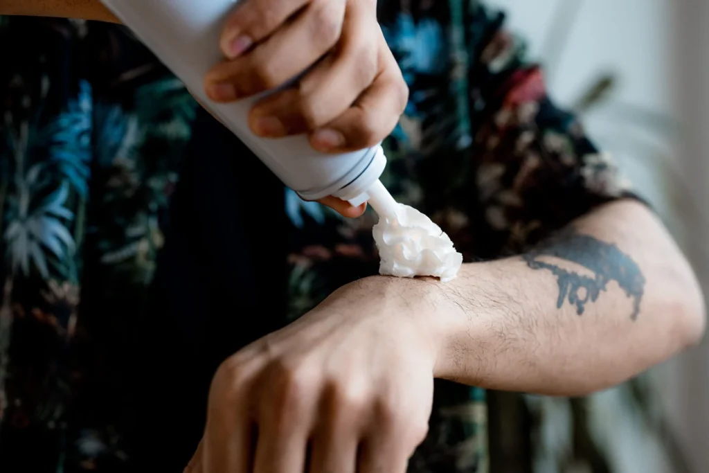 Application d'une crème sur un avant-bras tatoué